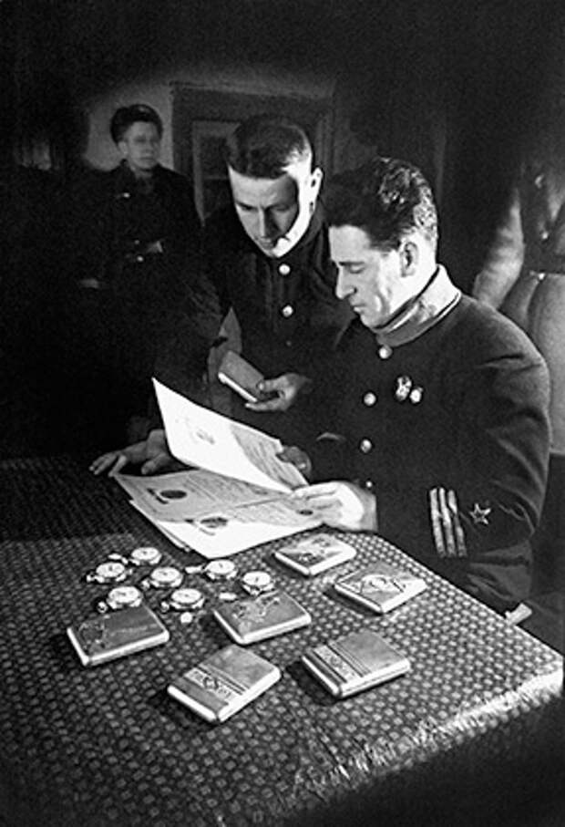 Батальонный комиссар Шаинский (справа) рассматривает подарки, присланные к Новому году для лучших бойцов и командиров