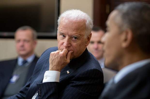 Joe Biden listening to former President Barack Obama during a meeting.