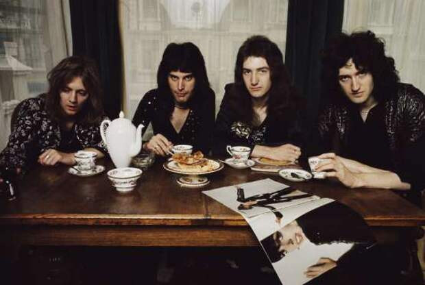 LONDON - 1st JANUARY: English rock group Queen posed at a dining table in lead singer Freddie Mercury's flat, Holland Road, West Kensington, London in early 1974. Left to right: Roger Taylor, Freddie Mercury (1946-1991), John Deacon and Brian May. (Photo by Mark and Colleen Hayward/Redferns)