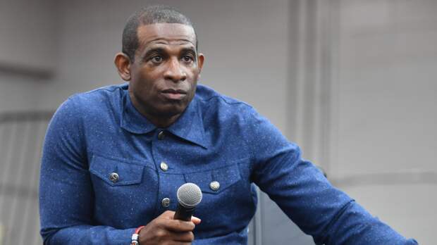 Deion Sanders speaks at an event.