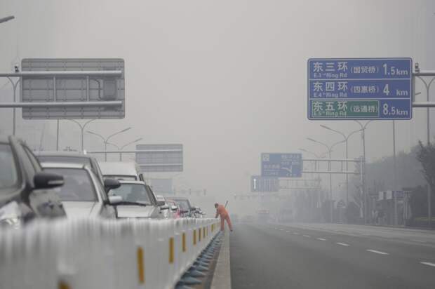 Уборщик на главной дороге в центре Пекина загрезнение, китай, природа