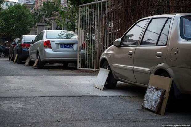 В Китае многие водители во время парковки прикрывают колеса на своей машине куском фанеры или старой дверцей от шкафа. Зачем они это делают?