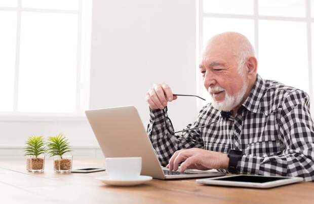 A smiling person at a laptop.