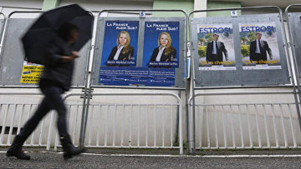 Женщина проходит мимо избирательных плакатов, Франция. Архив