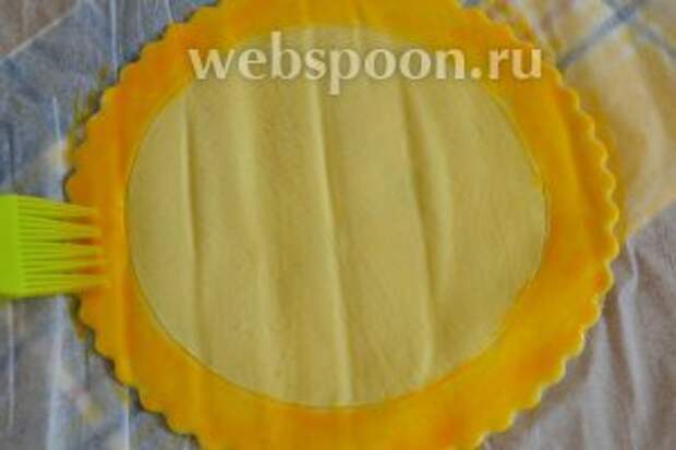 Яичный желток слегка взбить с 2 ст. л. воды и смазать кромку диска.