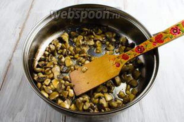 Разогреть сковороду с подсолнечным и топлёным сливочным маслом. Выложить подготовленные грибы. Жарить, помешивая, пока жидкость не испарится. 