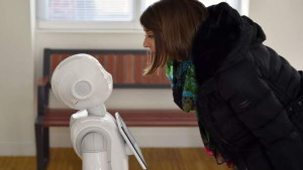 Женщина взаимодействует с роботом, предоставляющим информацию пассажирам французской железнодорожной компании SNCF