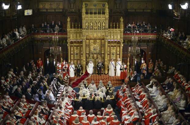 Затем королева зачитывает текст тронной речи, который подает ей лорд-канцлер (высший сановник Великобритании). На фото: Елизавета II во время обращения к парламенту в Вестминстерском дворце, 2014 год 