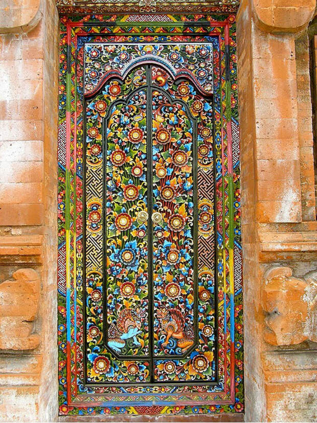 Яркая дверь, украшенная разноцветной мозаикой.