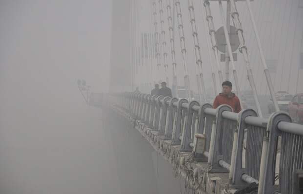 Горожане идут через мост. Видимость очень ограничена в связи с густым смогом загрезнение, китай, природа