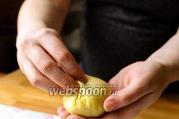 Переверните тесто вверх ногами и защипните удлинившиеся края булочки пальцами.