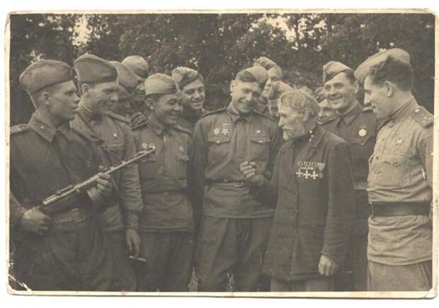Георгиевский кавалер бывший артиллерист Олексій Манилович Шамриха среди советских солдат. 1943 год.