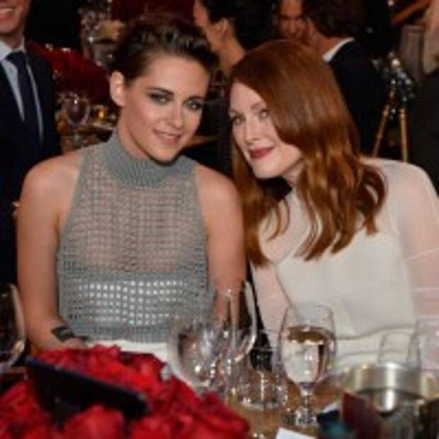 Kristen Stewart flared white skirt rising up gray crop top with pair of Casadei shoes