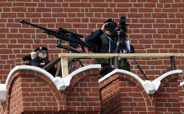 Снайперы ФСО занимают позицию по верхнему краю Кремлевской стены перед началом до Парада Победы на Красной площади в Москве