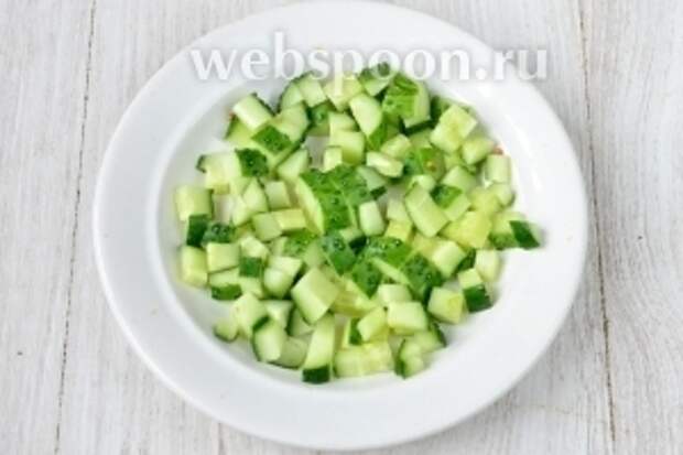 Нарезаем огурец мелкими кубиками.