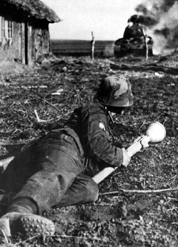 12. Пехотинец Ваффен СС с гранатомётом Панцерваффен в руках. На заднем плане горит советский Т-34. 1944-й год Вторая, война, мирова, фото