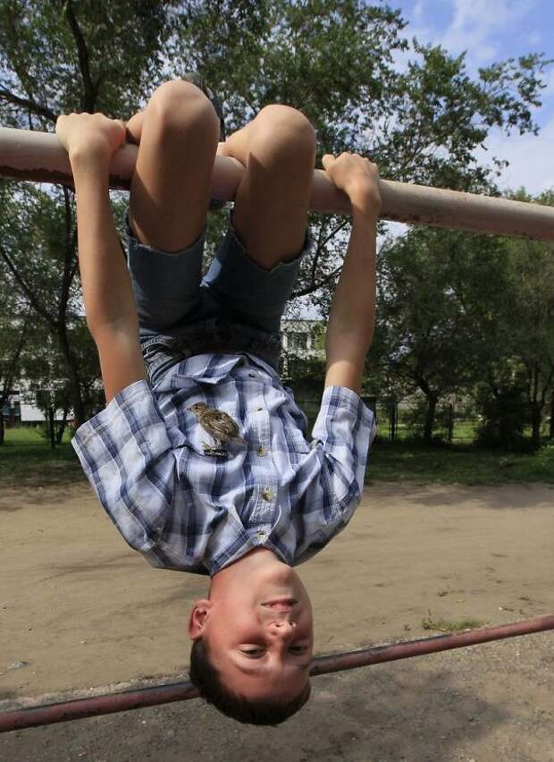 Veligurov hangs from a bar with Abi, a wild sparrow, near his grandmother's house in the town of Minusinsk