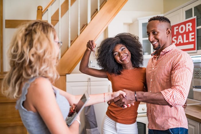 Real estate agent congratulating a new owner for buying new house