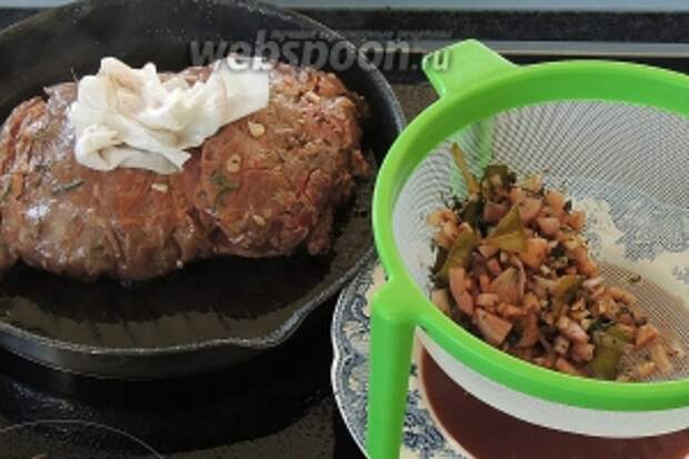 Процеживаем маринад от трав и отставим в сторону, он нам ещё понадобится. Мясо промокнём салфеткой и снимем травы.