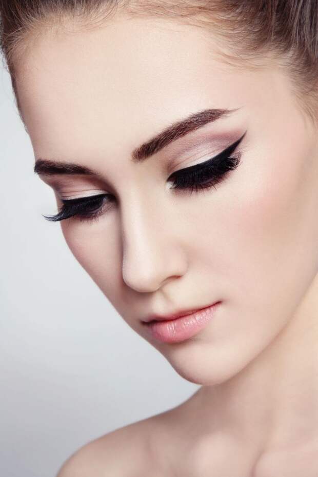 Close-up portrait of young beautiful girl with cat eye make-up