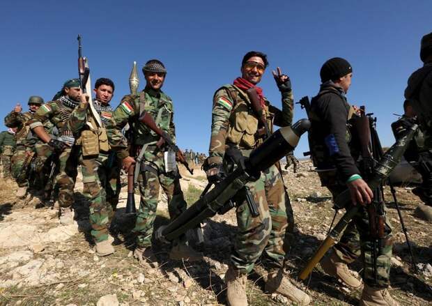 Members of the Kurdish peshmerga forces gather in the town of Sinjar