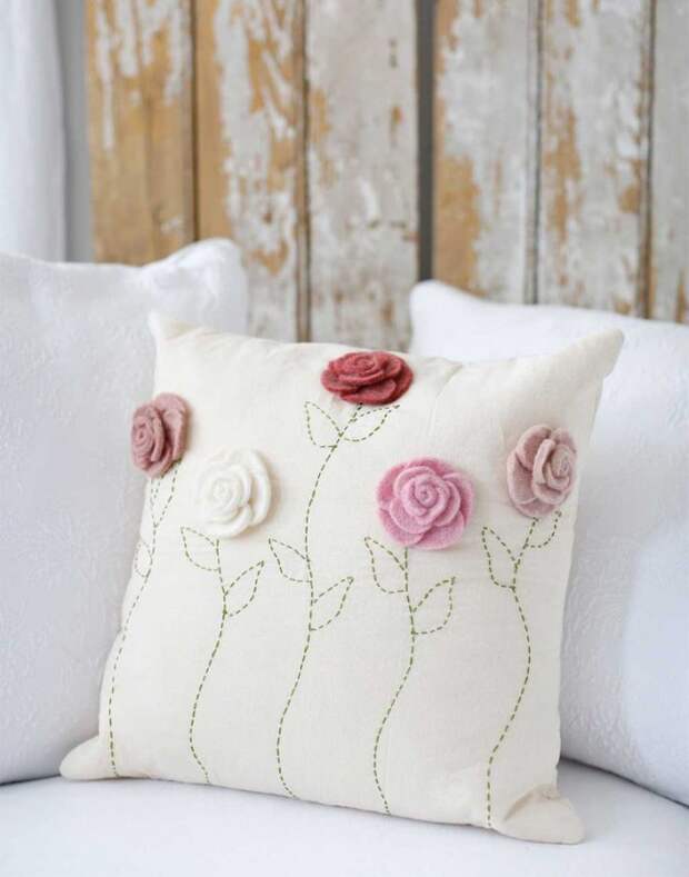 Белую подушку можно украсить небольшими цветами из мягкого текстиля