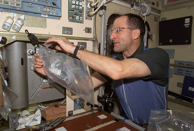 Бортинженер Дональд Петтит (6-я экспедиция МКС) собирает пробы воды на анализ (водонагреватель в модуле «Звезда»)