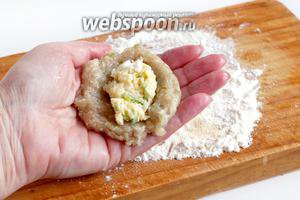 Влажными руками сформировать лепёшку из фарша, в центр положить немного начинки и слепить котлету.