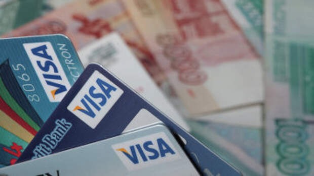 Пластиковые карты Visa и денежные купюры достоинством 1000 и 5000 рублей. Архивное фото