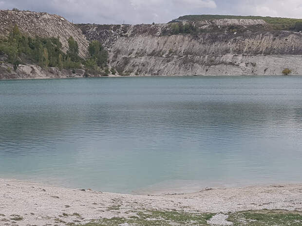 Озеро окружают белоснежные скалы из известняка.