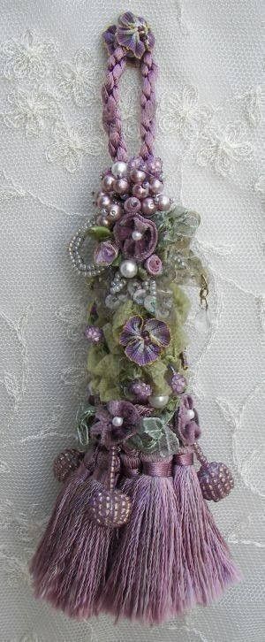 j'aime les multiples pompons dans le bas et les rubans, fleurs et perles le long de la cordeliÃ¨re