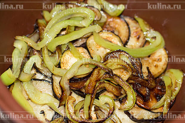 Тушить овощи лучше всего в кастрюле с толстым дном и стенками. Выкладываем баклажаны первым слоем, на них - обжаренный перец.