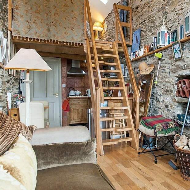 На условном первом этаже находятся кухонный уголок (его видно на этом фото), туалет + душ (белая дверь рядом с кухней) и комната-гостиная. Наверху — небольшая спальня, рассчитанная на двух человек