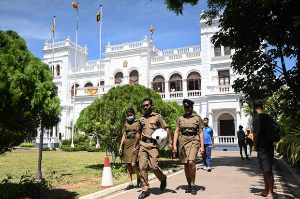Полиция идет по лужайке возле офисного здания премьер-министра Шри-Ланки в Коломбо