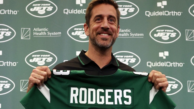 Aaron Rodgers poses with Jets jersey at introductory press conference