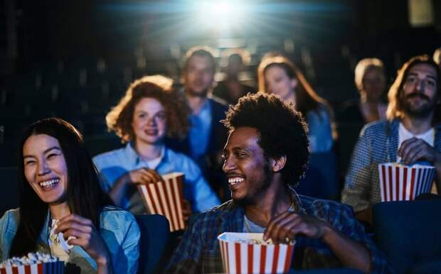 People eating popcorn while sitting in a movie theater.