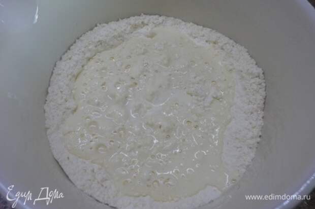 Холодное сливочное масло перетереть с мукой и разрыхлителем в масляную крошку. Сметану смешать с яйцами, солью, сахаром, ледяной водой и вылить в масляную крошку.