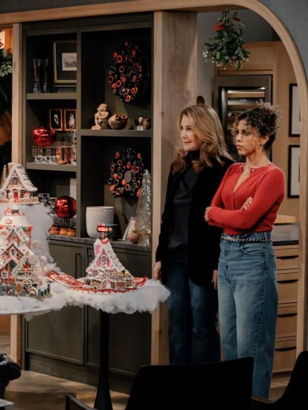 Roz & Eve stand with gingerbread village