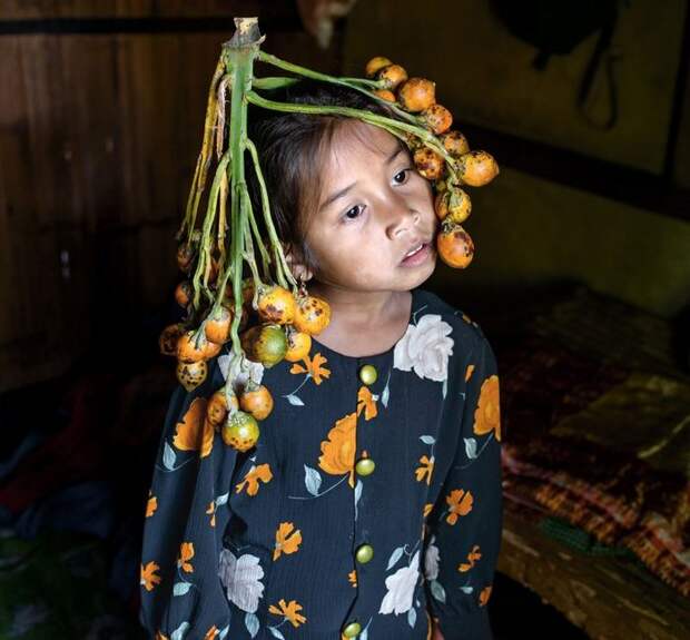Аниша Нонгрум в головном уборе из плодов пальмы арека (которые больше известны, как жевательный бетель).