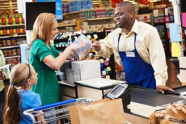 Woman selecting coupons from a container at the store checkout