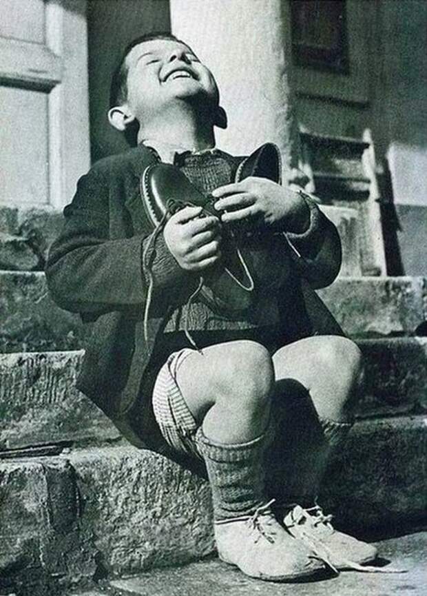 Шестилетний мальчик из приюта получил в подарок от Красного Креста новые ботинки, 1946 год.