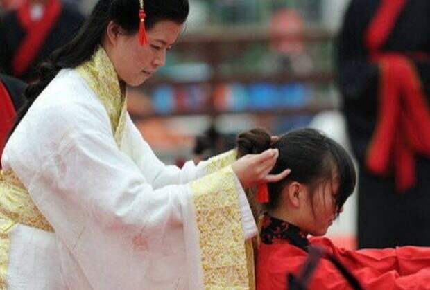 Женщина закалывает волосы девочке