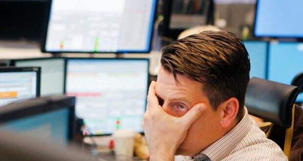 A broker looks at his screens at the stock exchange in Frankfurt, Germany today. The stock index DAX fell under 8500 points. (Photograph: Michael Probst/AP)