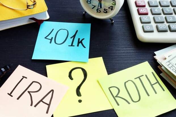 Sticky notes on a desk reading 401k, IRA, Roth, ?.