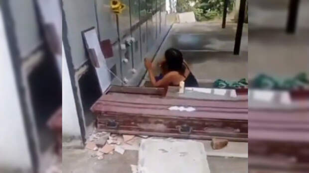 Вдова сидит у гроба мужа / Кадр из видео: NSFW