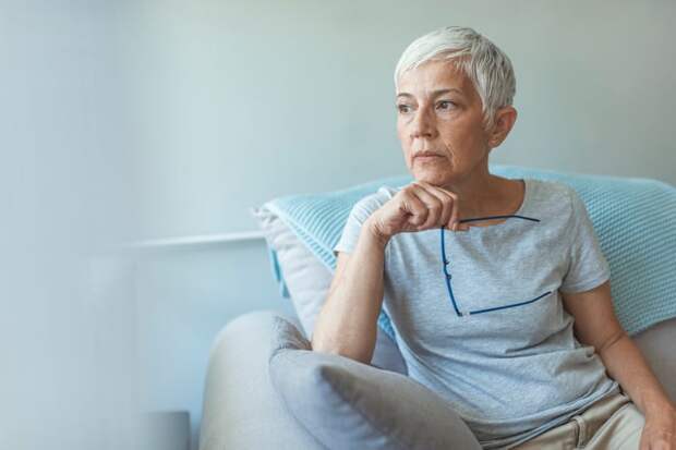 Person with a serious expression sitting in a chair.