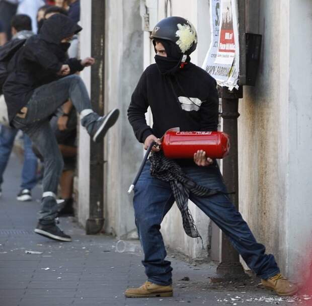A demonstrator holds a fire extinguisher during a demonstration of the 'Indignant' group against banking and finance in Rome