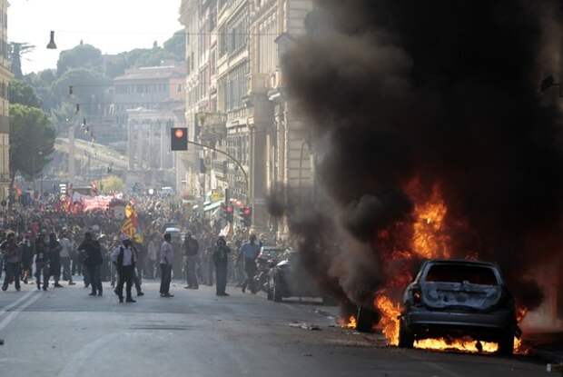 Cars burn during a demonstration of the 'Indignant' group against banking and finance in Rome