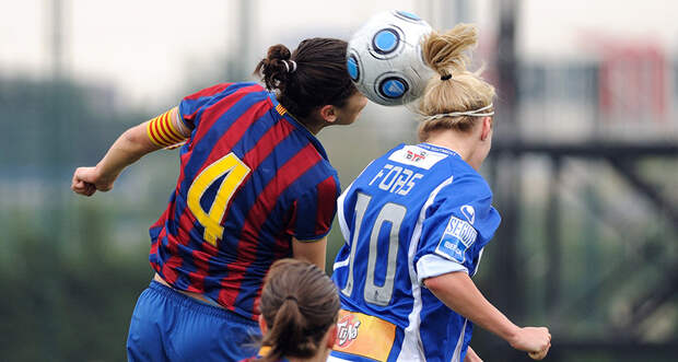 woman heading a soccer ball