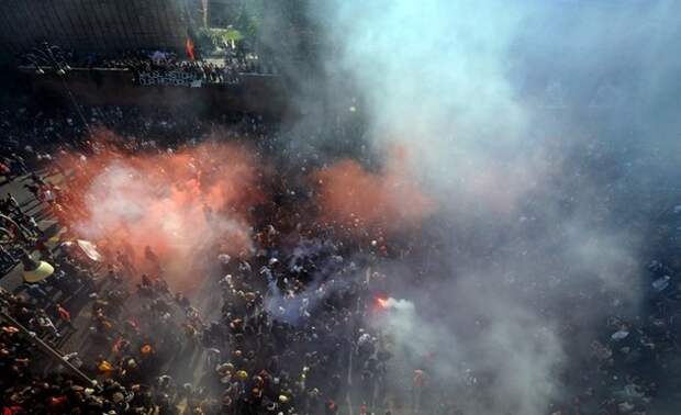 Protesters march through smoke of flares